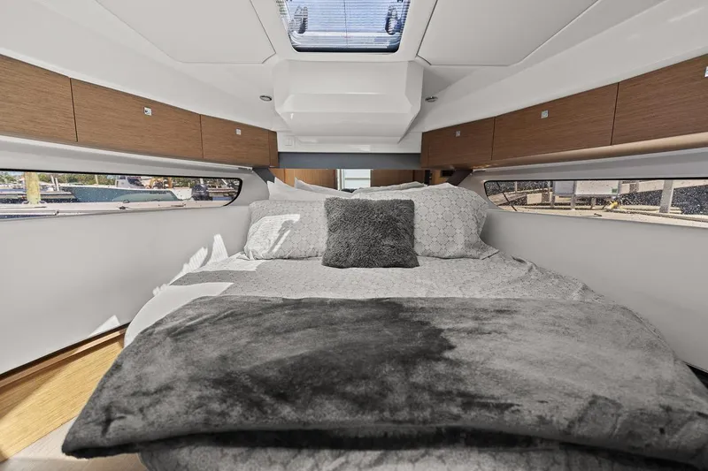 Trinity Yacht Photos Pics Luxurious cabin interior of 2020 Jeanneau NC 1095 Fly with plush bedding and skylight.