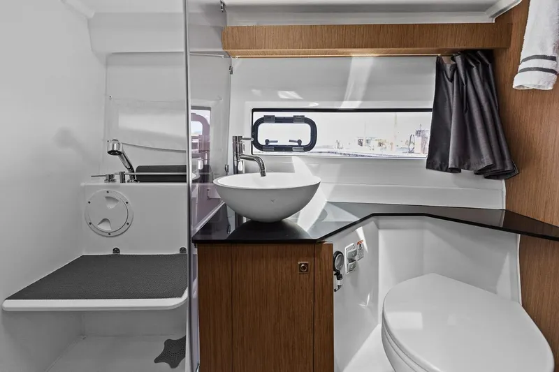 Trinity Yacht Photos Pics Modern bathroom interior on 2020 Jeanneau NC 1095 Fly boat, featuring sleek fixtures and wood accents.