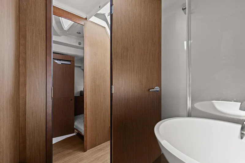 Trinity Yacht Photos Pics Interior of 2020 Jeanneau NC 1095 Fly, featuring wood paneling and modern bathroom fixtures.