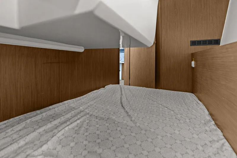 Trinity Yacht Photos Pics Interior cabin view of 2020 Jeanneau NC 1095 Fly, featuring a cozy bed and wooden paneling.