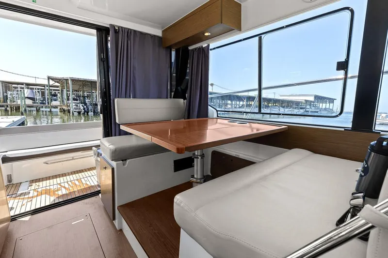 Trinity Yacht Photos Pics Interior of 2020 Jeanneau NC 1095 Fly boat with dining area and marina view.