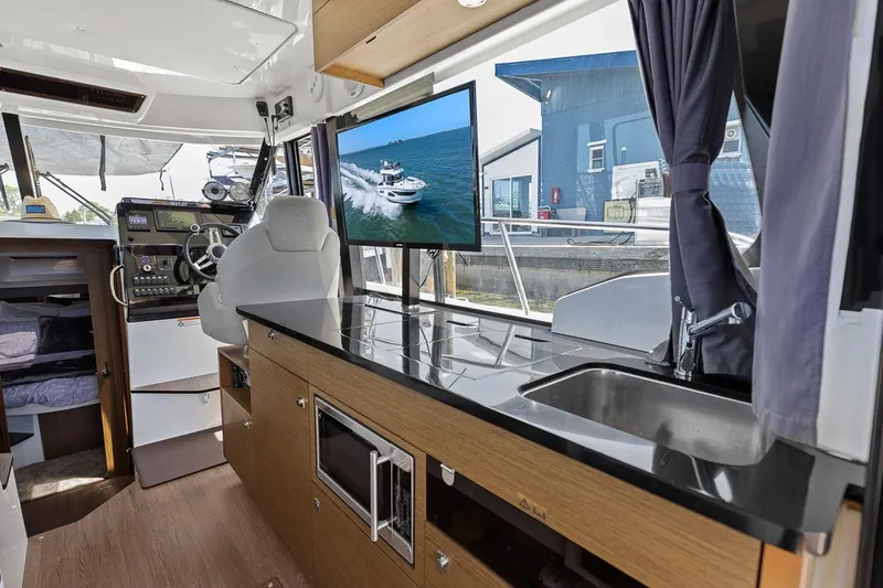 Trinity Yacht Photos Pics Interior of 2020 Jeanneau NC 1095 Fly boat with modern kitchen and navigation area.