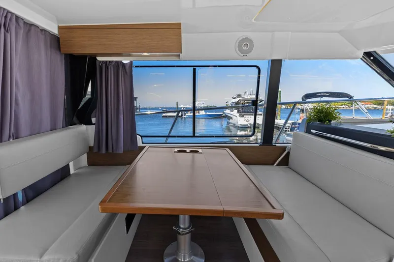 Trinity Yacht Photos Pics Interior of 2020 Jeanneau NC 1095 Fly yacht with dining area and marina view.