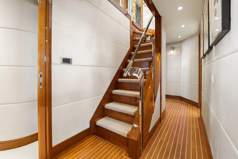Penelope Yacht Photos Pics Luxurious interior of 1990 Delta Expedition yacht with wooden staircase and modern lighting.