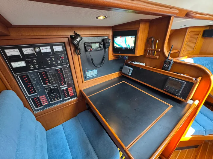 Elena Yacht Photos Pics Navigation station of a 1998 Hylas 46 yacht with control panels and seating.