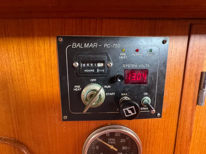 Elena Yacht Photos Pics Control panel of a 1998 Hylas 46 sailboat, displaying system volts and engine hours.