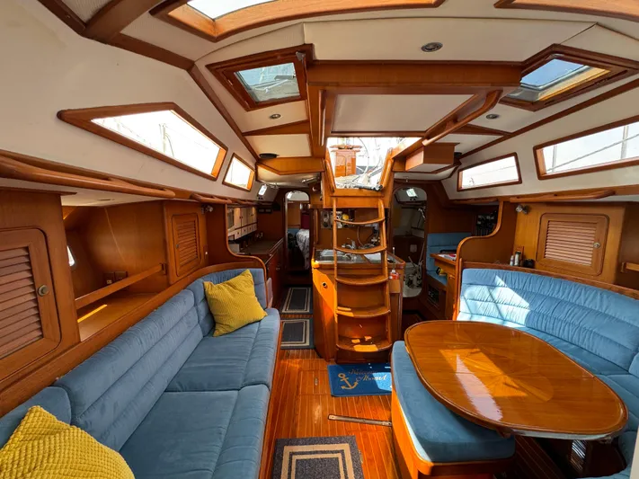 Elena Yacht Photos Pics Luxurious 1998 Hylas 46 yacht interior with wooden finishes and blue seating.