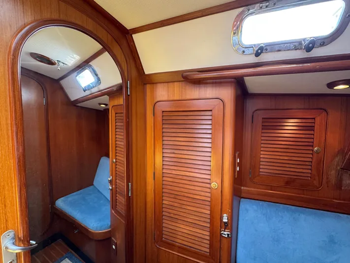 Elena Yacht Photos Pics Interior of 1998 Hylas 46 yacht with wooden paneling and blue seating.