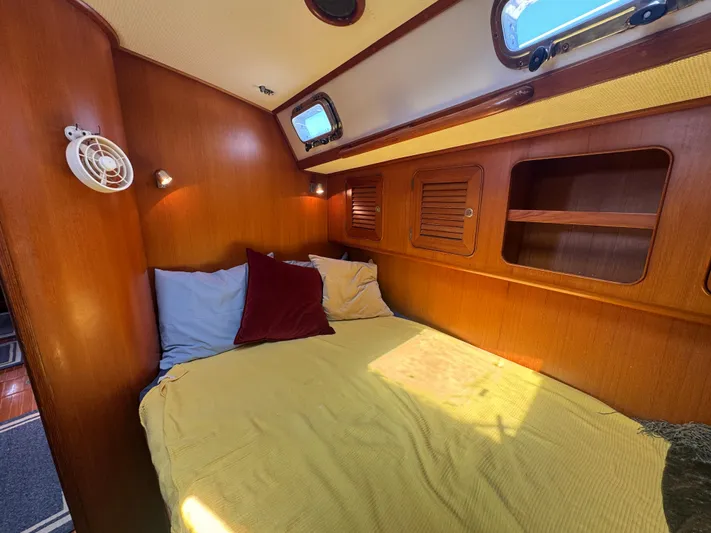 Elena Yacht Photos Pics Cozy cabin interior of a 1998 Hylas 46 yacht with wooden paneling and bedding.