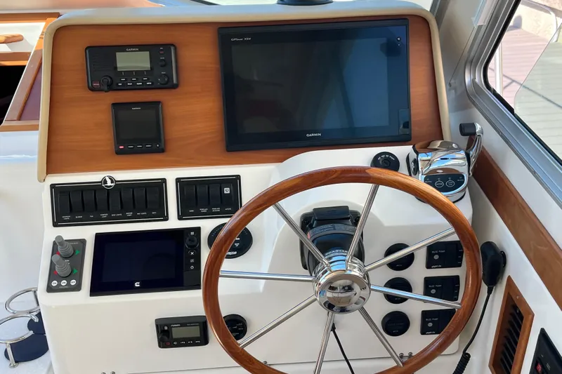 Phalarope Yacht Photos Pics 2017 Back Cove 37 helm with Garmin navigation, wooden steering wheel, and control panel.