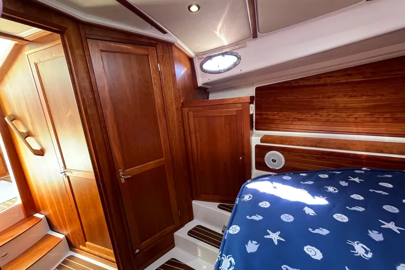 Phalarope Yacht Photos Pics 2017 Back Cove 37 cabin interior with wooden finish and nautical-themed bedding.