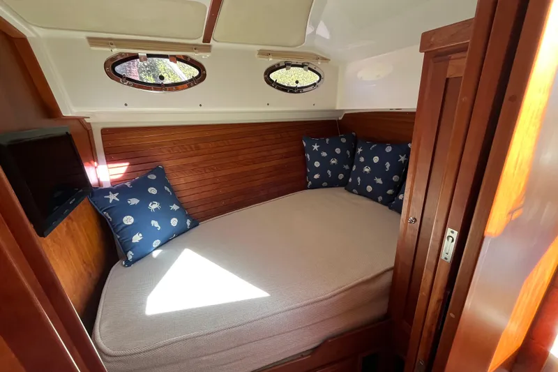 Phalarope Yacht Photos Pics Cozy cabin interior of 2017 Back Cove 37 with nautical-themed pillows and wooden accents.
