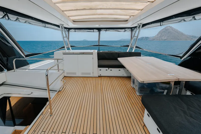  Yacht Photos Pics Luxurious 2017 Lagoon 630 Motor Yacht interior with ocean view, featuring sleek seating and wooden flooring.
