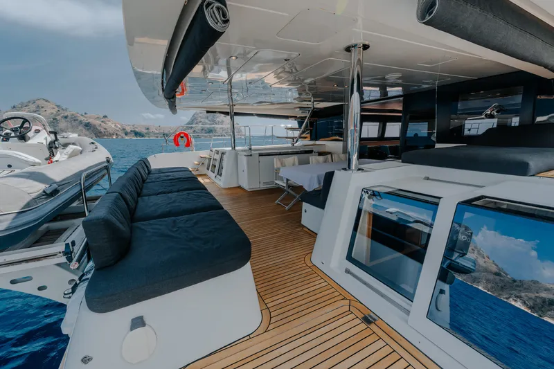  Yacht Photos Pics Luxurious 2017 Lagoon 630 Motor Yacht deck with seating, ocean view, and island backdrop.