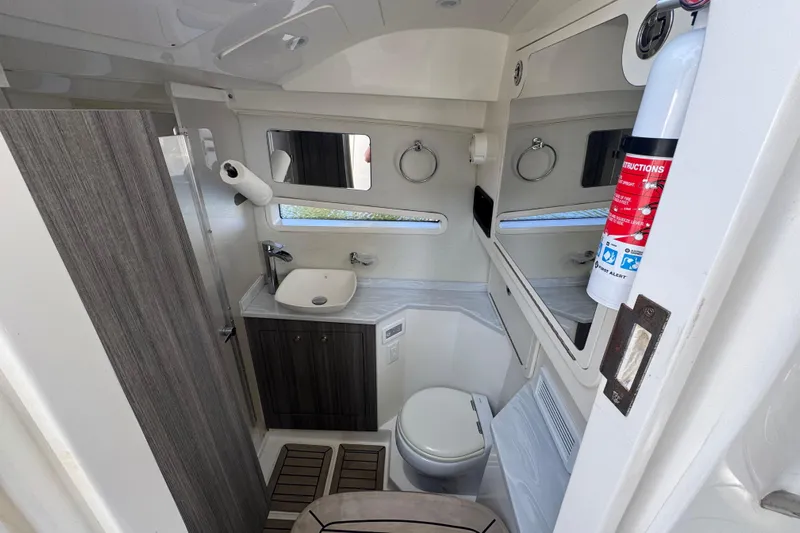  Yacht Photos Pics Luxurious 2021 World Cat 400 DC-X boat bathroom with modern fixtures and fire extinguisher.