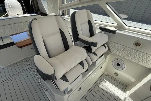  Yacht Photos Pics Luxurious seating in 2021 World Cat 400 DC-X boat interior, featuring plush white and gray upholstery.