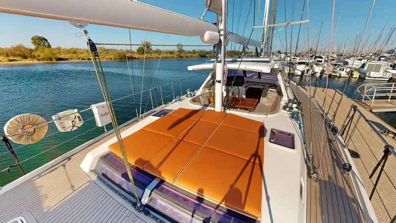  Yacht Photos Pics Luxurious 2011 Amel 55 yacht docked at marina, featuring spacious deck and orange sunbathing cushions.