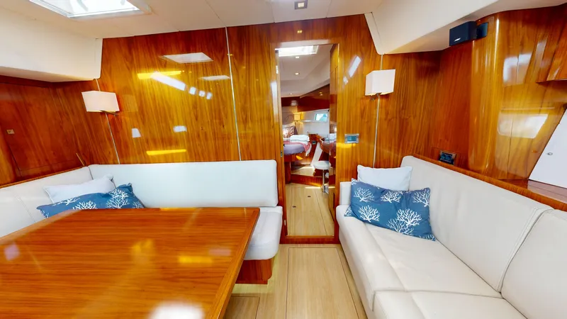  Yacht Photos Pics Luxurious interior of 2011 Amel 55 yacht with wooden finish and white seating.