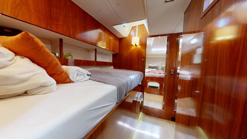  Yacht Photos Pics Luxurious cabin interior of 2011 Amel 55 yacht with wooden finish and cozy bedding.