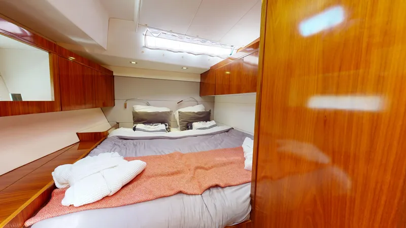  Yacht Photos Pics Luxurious cabin interior of 2011 Amel 55 yacht with cozy bedding and wooden finishes.