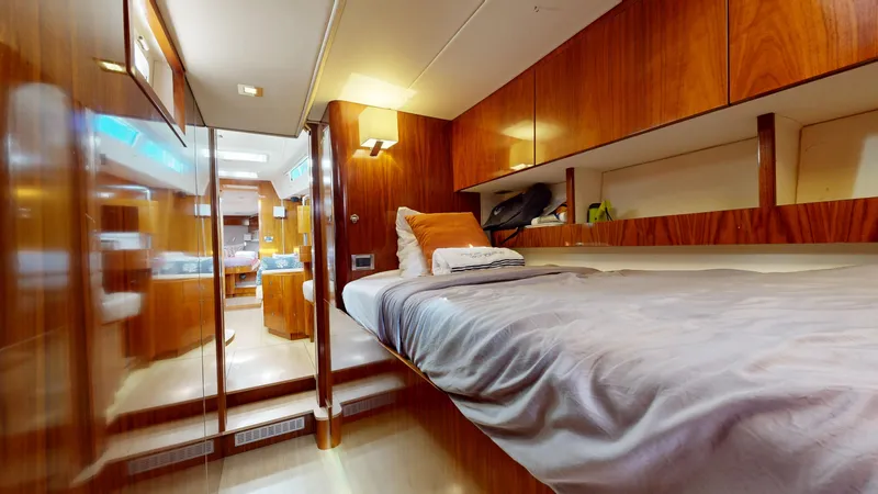  Yacht Photos Pics Luxurious cabin interior of 2011 Amel 55 yacht with wooden finishes and cozy bedding.