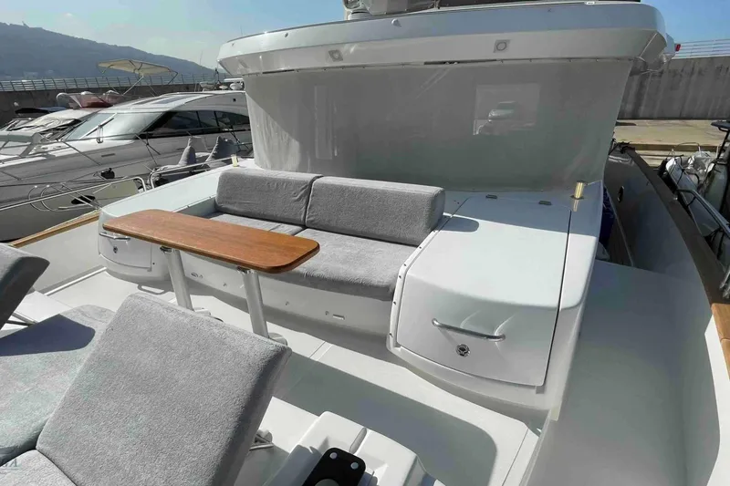  Yacht Photos Pics 2022 Sirena 58 yacht with outdoor seating and wooden table on deck.