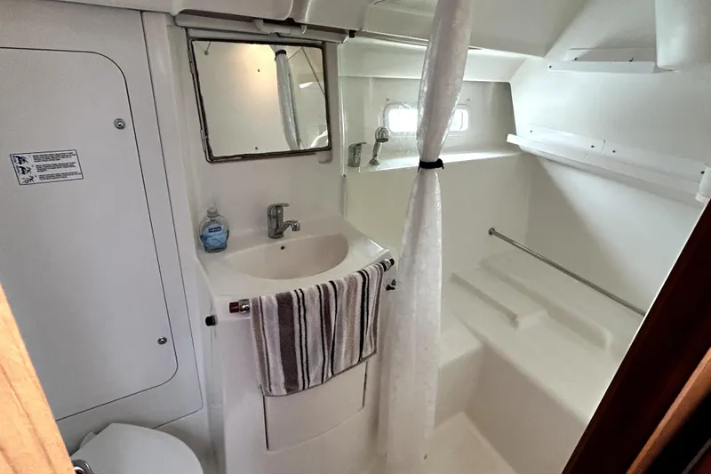 Notos Yacht Photos Pics Bathroom interior of 2005 Beneteau Oceanis 373 yacht, featuring sink, mirror, and shower area.