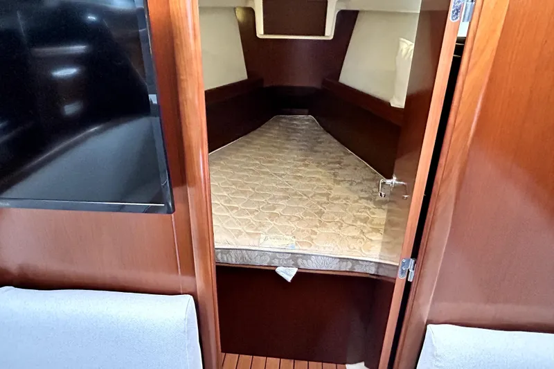 Notos Yacht Photos Pics Interior cabin of 2005 Beneteau Oceanis 373 sailboat with mattress and wooden finish.