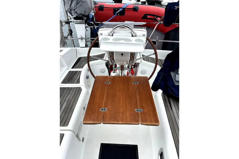 Notos Yacht Photos Pics Cockpit of 2005 Beneteau Oceanis 373 sailboat with wooden table and steering wheel.