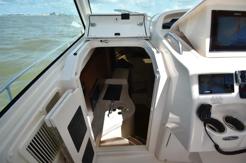 Policy Maker Yacht Photos Pics 2016 Grady-White Express 330 cabin interior with navigation equipment and open hatch.