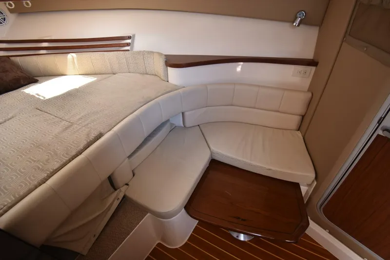 Policy Maker Yacht Photos Pics Interior of 2016 Grady-White Express 330, featuring a cozy seating area and wooden table.