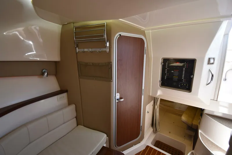 Policy Maker Yacht Photos Pics 2016 Grady-White Express 330 cabin interior with seating, control panel, and wooden door.
