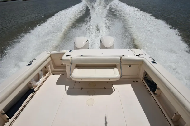 Policy Maker Yacht Photos Pics 2016 Grady-White Express 330 boat cruising, view from stern with wake in water.
