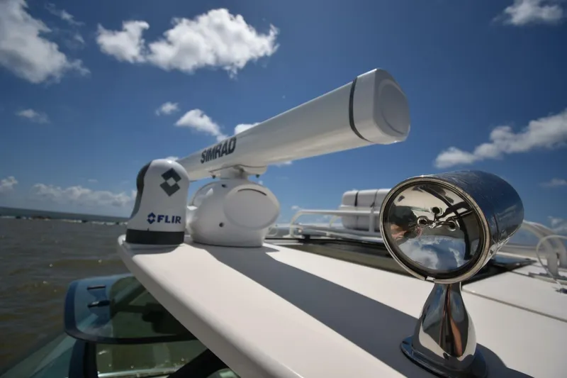 Policy Maker Yacht Photos Pics Radar and spotlight on 2016 Grady-White Express 330 boat under blue sky.