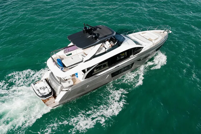  Yacht Photos Pics 2023 Azimut Fly 68 yacht cruising on turquoise waters, aerial view.