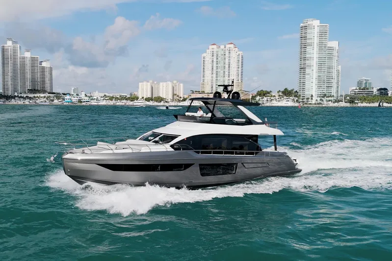  Yacht Photos Pics 2023 Azimut Fly 68 yacht cruising near city skyline on a sunny day.