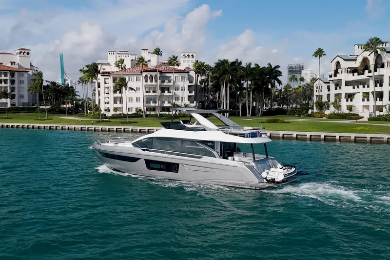  Yacht Photos Pics 2023 Azimut Fly 68 yacht cruising near luxury waterfront residences.
