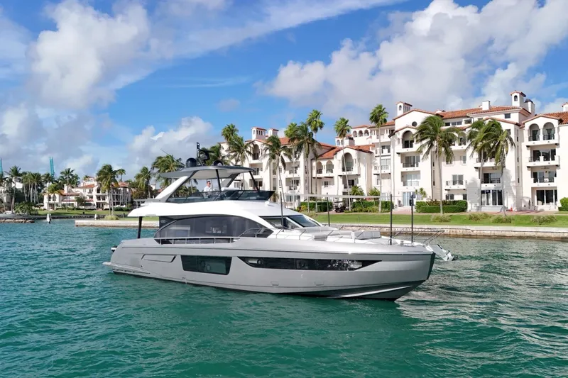  Yacht Photos Pics 2023 Azimut Fly 68 yacht cruising near luxury waterfront residences.