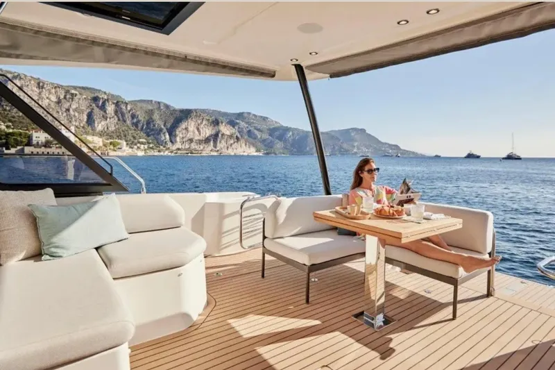  Yacht Photos Pics Luxury yacht Prestige M48 2023, woman relaxing with breakfast, scenic ocean view.