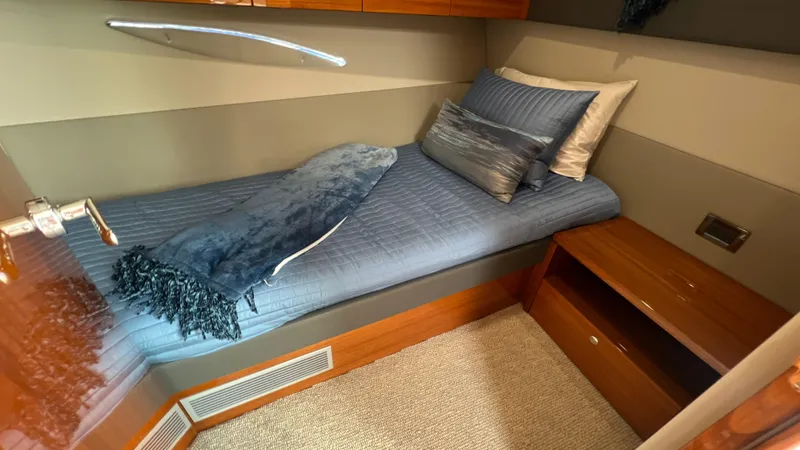 Trigal Yacht Photos Pics 2021 Maritimo X60 cabin with single bed, blue bedding, and wooden storage.