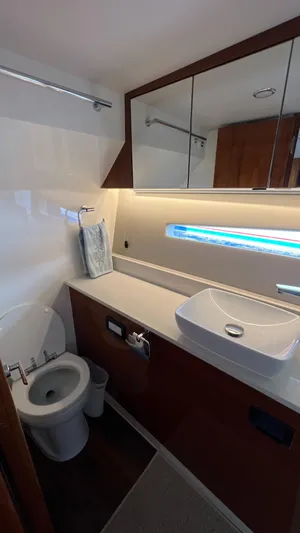 Trigal Yacht Photos Pics 2021 Maritimo X60 yacht bathroom with modern sink, toilet, and mirrored cabinet.