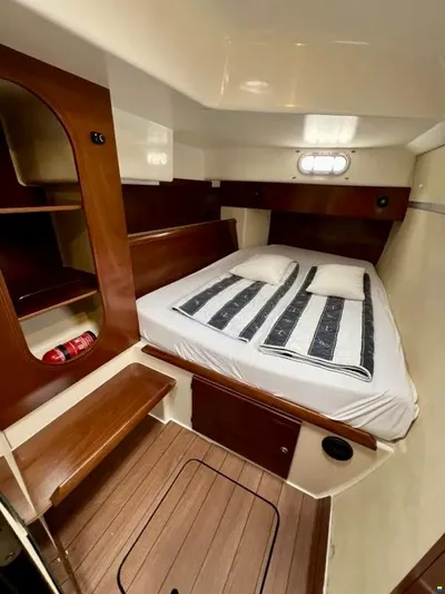  Yacht Photos Pics 2005 Fountaine Pajot LAVEZZI 40 cabin with bed, wooden shelves, and porthole window.