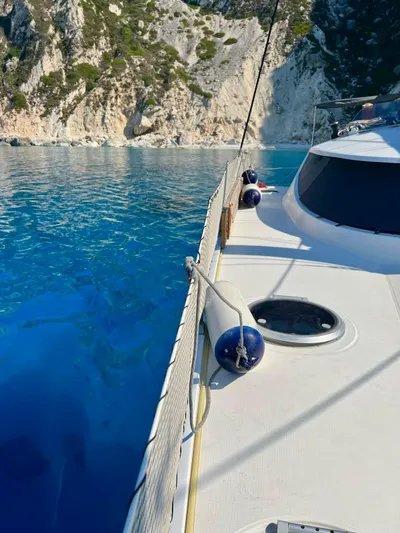  Yacht Photos Pics 2005 Fountaine Pajot LAVEZZI 40 catamaran on clear blue water near rocky cliffs.