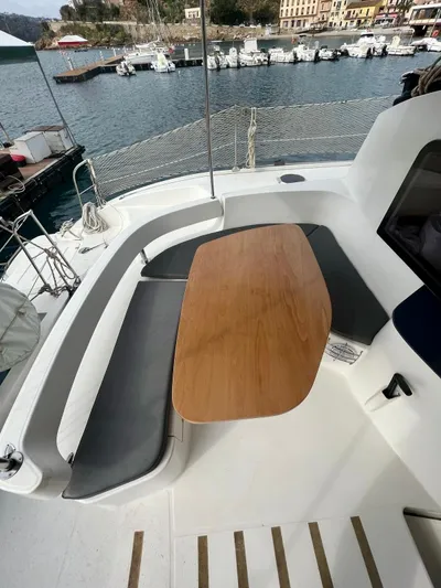  Yacht Photos Pics 2005 Fountaine Pajot LAVEZZI 40 catamaran cockpit with wooden table and seating, docked at marina.