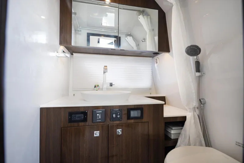  Yacht Photos Pics Luxurious bathroom in 2022 New Cruiser Yachts GLS 38 with modern fixtures and wood accents.