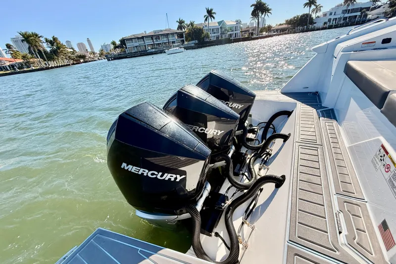  Yacht Photos Pics 2022 New Cruiser Yachts GLS 38 with triple Mercury outboard engines on a sunny waterfront.