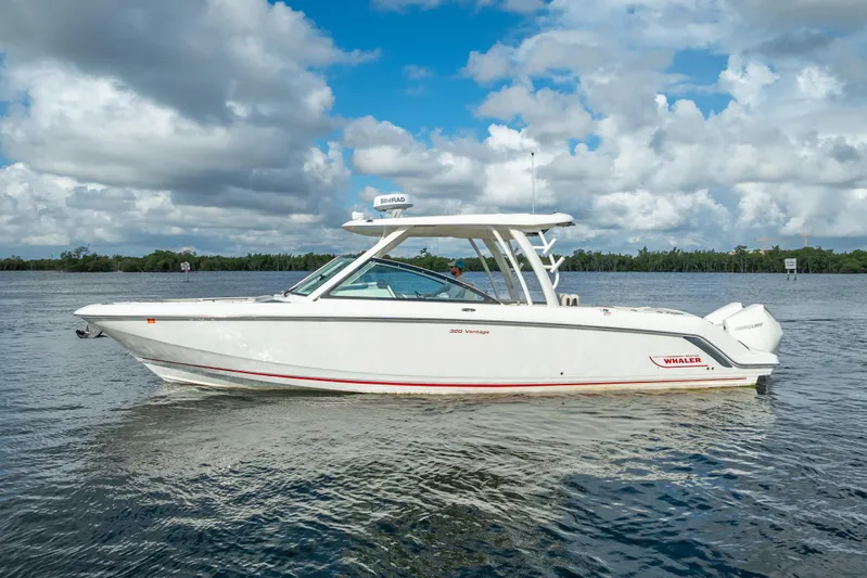 Trade In-- Bring All Offers & Trades Yacht Photos Pics 2024 Boston Whaler 320 Vantage boat on calm water under a cloudy sky.