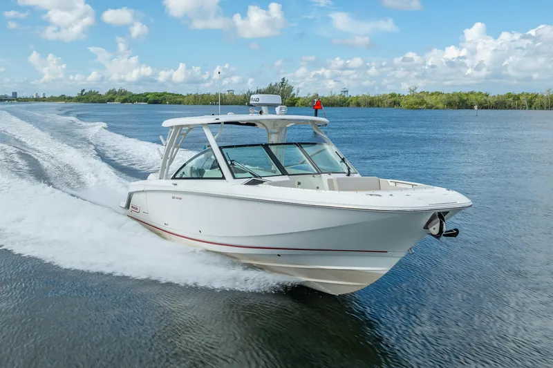 Trade In-- Bring All Offers & Trades Yacht Photos Pics 2024 Boston Whaler 320 Vantage cruising on a sunny day, showcasing sleek design and performance.
