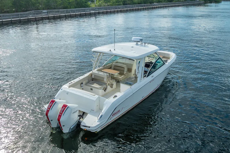 Trade In-- Bring All Offers & Trades Yacht Photos Pics 2024 Boston Whaler 320 Vantage boat cruising on a calm waterway.