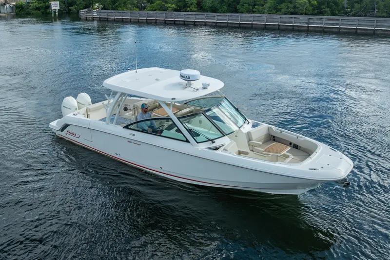 Trade In-- Bring All Offers & Trades Yacht Photos Pics 2024 Boston Whaler 320 Vantage boat cruising on a calm waterway.